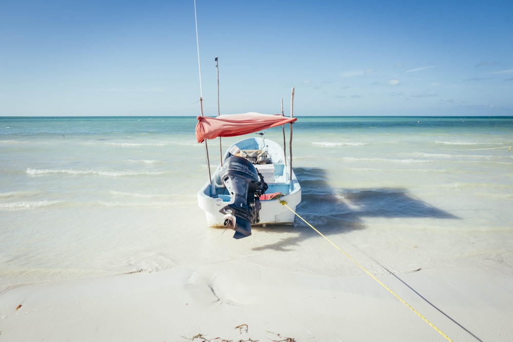 a man standing next to a boat on a beach