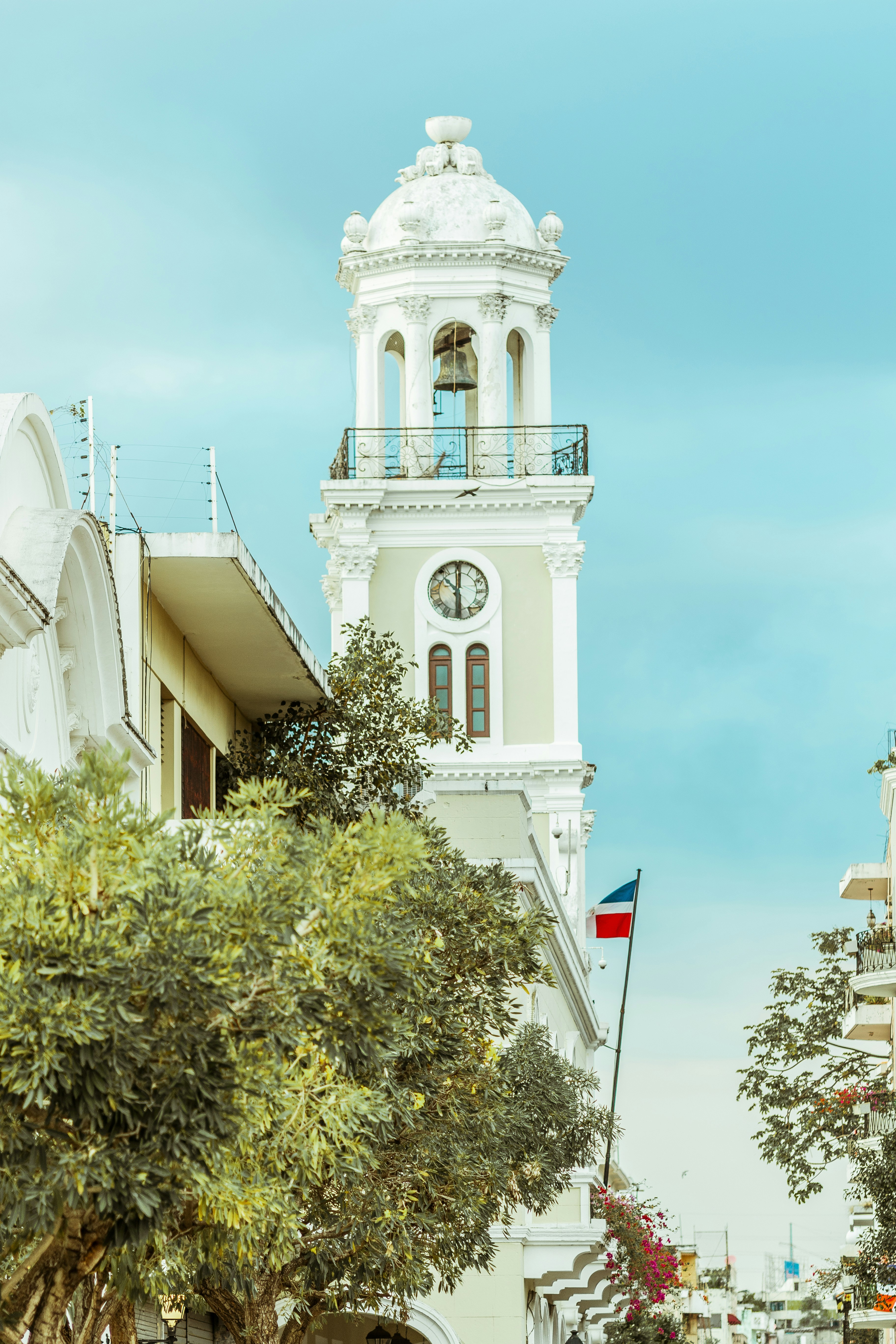 A tall white clock tower towering over a city photo – Free Zona ...