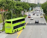 A large 74-seater coach navigating the M25, surrounded by lush greenery on a sunny day.