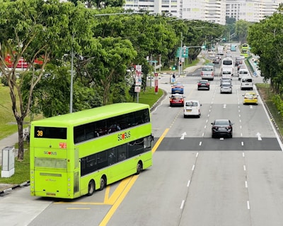 A large 74-seater coach navigating the M25, surrounded by lush greenery on a sunny day.