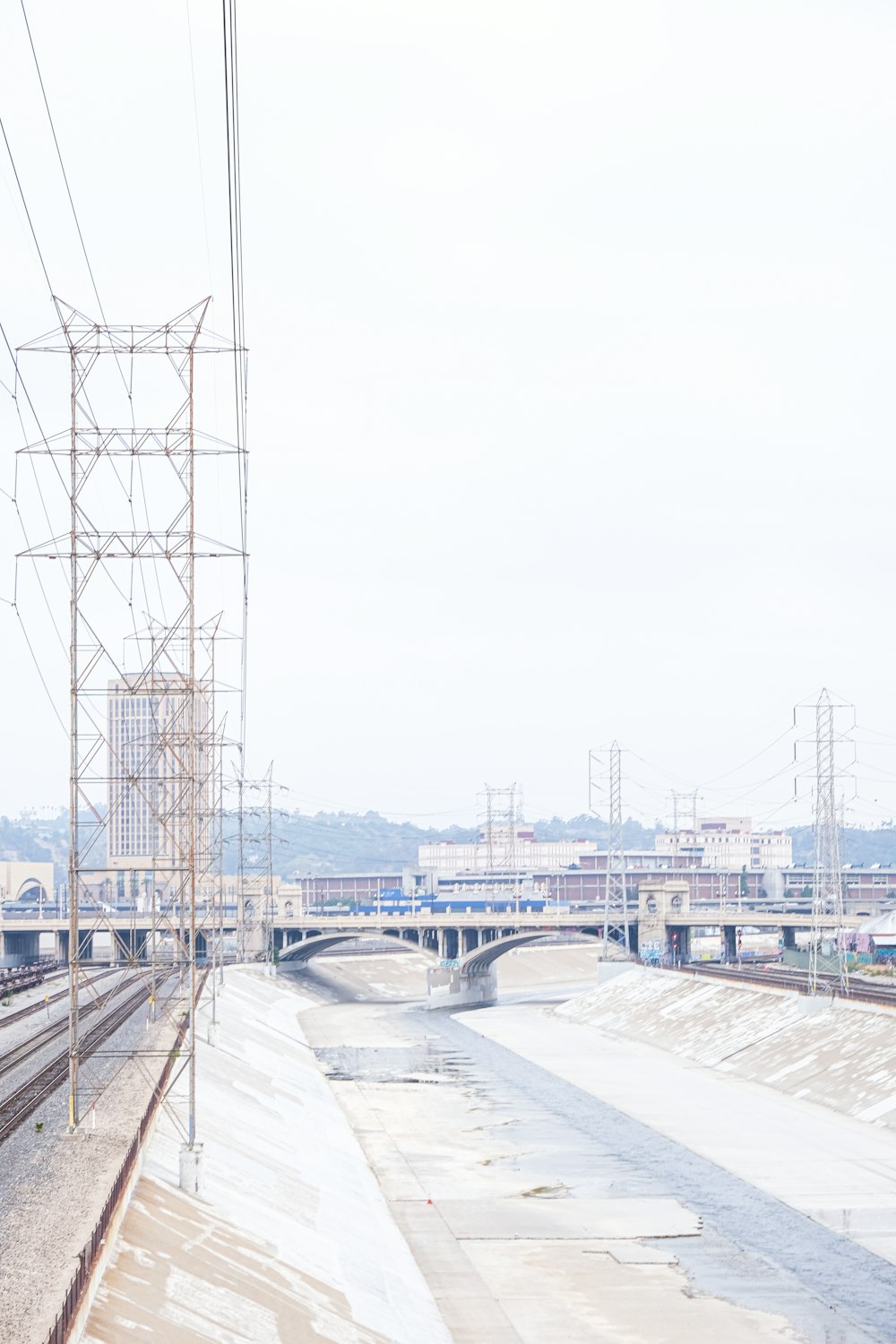 Ein Zug, der neben einer Brücke auf Bahngleisen fährt