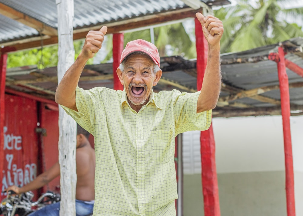 a man with a pink hat is raising his hands