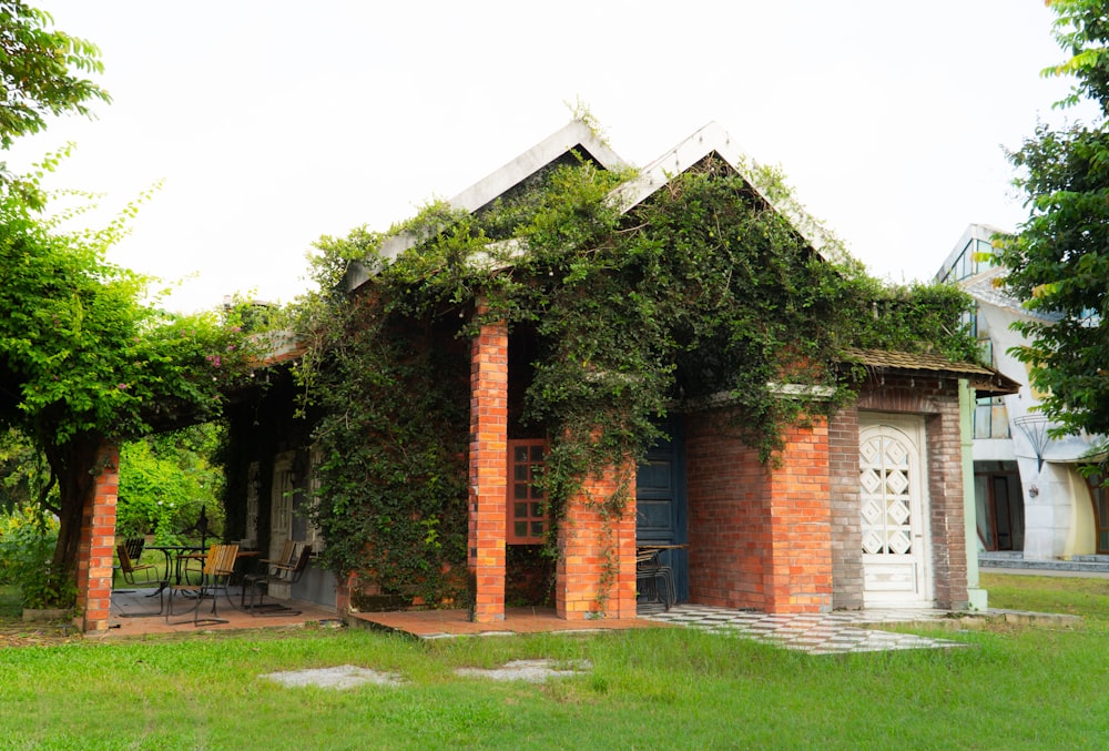 a small brick house covered in vines