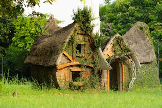 A serene view of lush greenery with a rustic mudhouse nestled among vibrant tropical plants and butterflies.