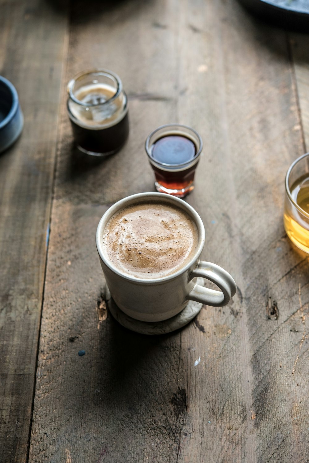 a wooden table topped with cups filled with liquid