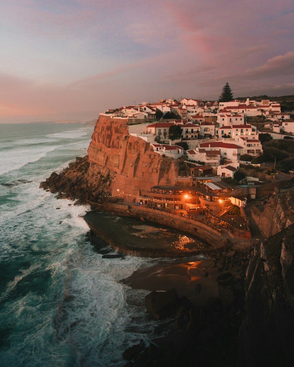 a view of a town on a cliff next to the ocean