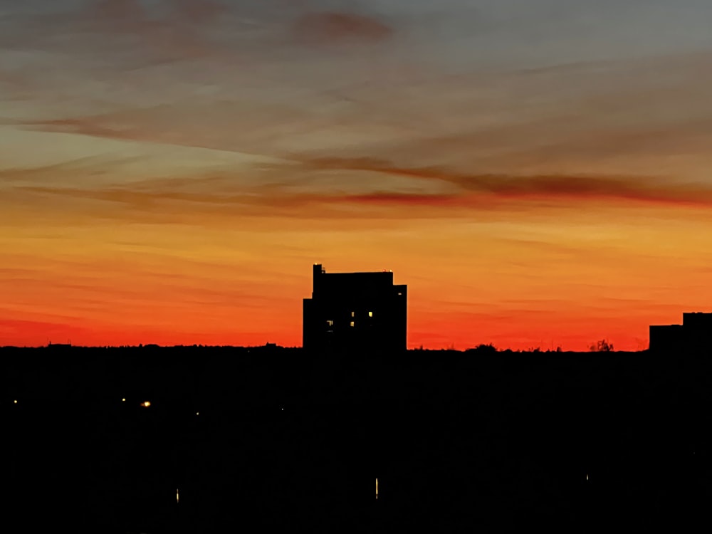 a sunset with a building in the foreground