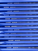 An array of blue packages stacked neatly in rows with 'Orkla' branding and nutritional information printed in white. The packaging appears uniform and organized.