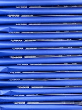 An array of blue packages stacked neatly in rows with 'Orkla' branding and nutritional information printed in white. The packaging appears uniform and organized.