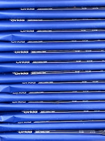 An array of blue packages stacked neatly in rows with 'Orkla' branding and nutritional information printed in white. The packaging appears uniform and organized.