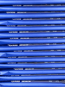 An array of blue packages stacked neatly in rows with 'Orkla' branding and nutritional information printed in white. The packaging appears uniform and organized.