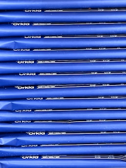 An array of blue packages stacked neatly in rows with 'Orkla' branding and nutritional information printed in white. The packaging appears uniform and organized.