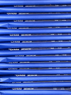 An array of blue packages stacked neatly in rows with 'Orkla' branding and nutritional information printed in white. The packaging appears uniform and organized.