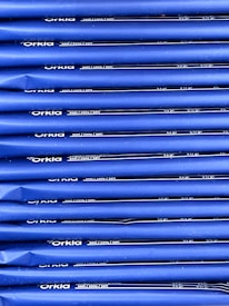 An array of blue packages stacked neatly in rows with 'Orkla' branding and nutritional information printed in white. The packaging appears uniform and organized.
