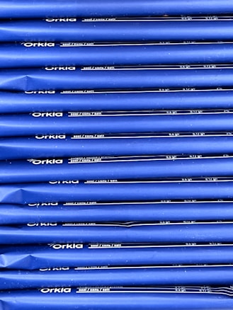 An array of blue packages stacked neatly in rows with 'Orkla' branding and nutritional information printed in white. The packaging appears uniform and organized.