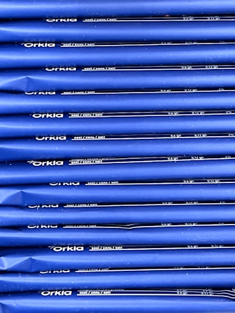 An array of blue packages stacked neatly in rows with 'Orkla' branding and nutritional information printed in white. The packaging appears uniform and organized.