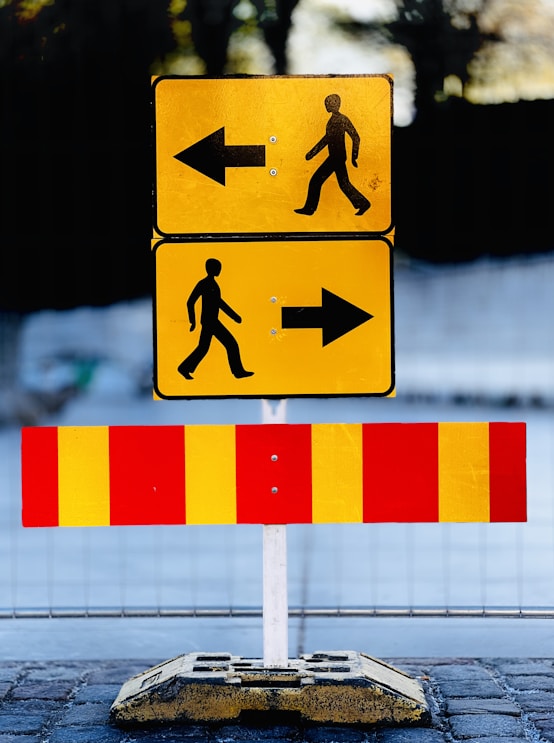 a pedestrian crossing sign on the side of the road