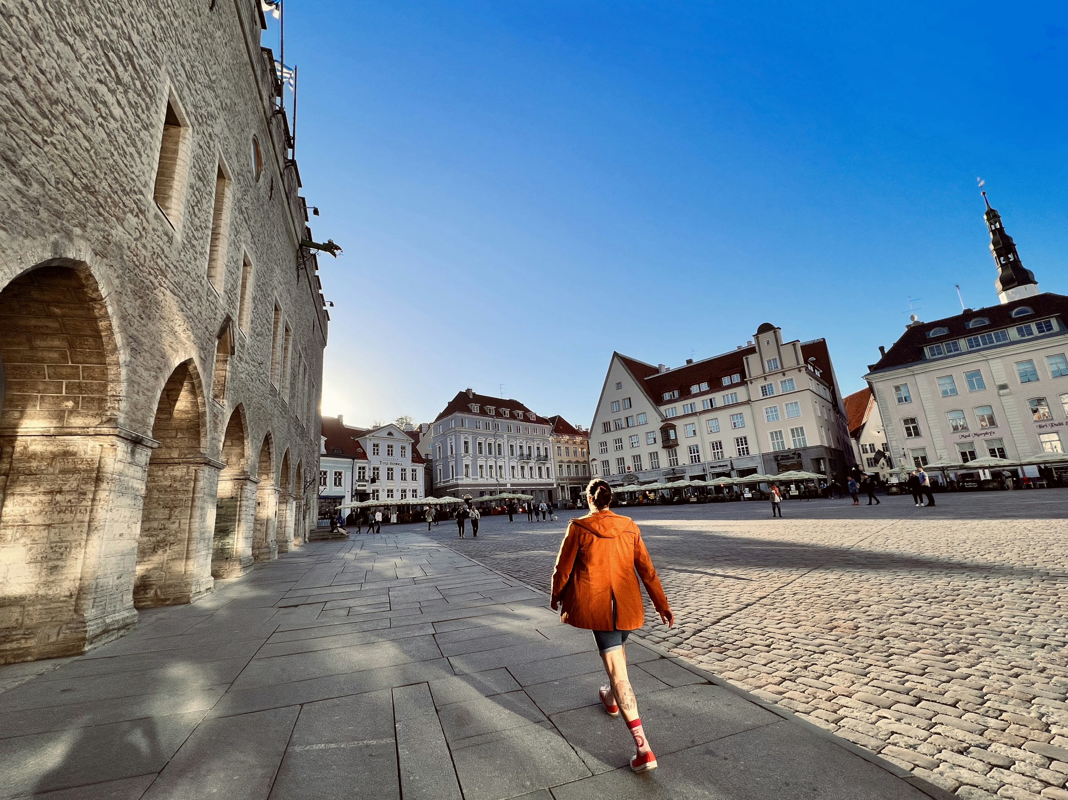 Una donna che cammina lungo una strada accanto a edifici alti