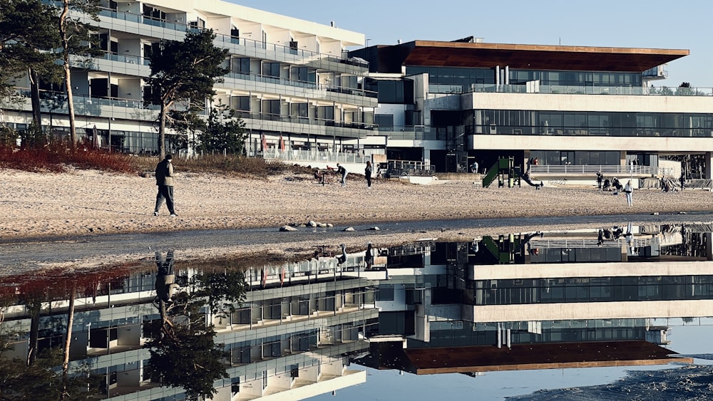 a person walking on a beach next to a building