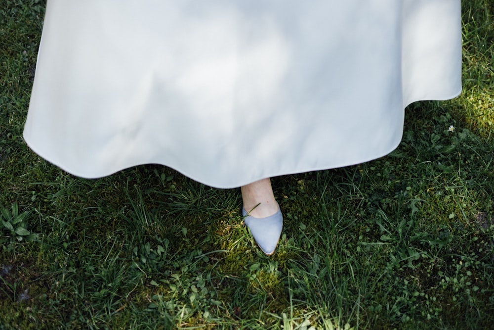 a woman in a white dress is standing in the grass