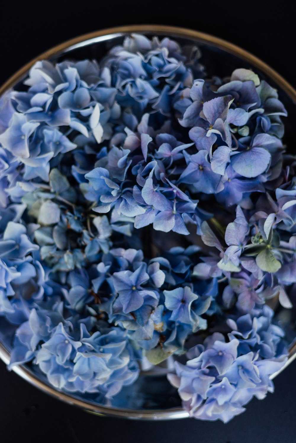 a bowl filled with blue flowers on top of a table