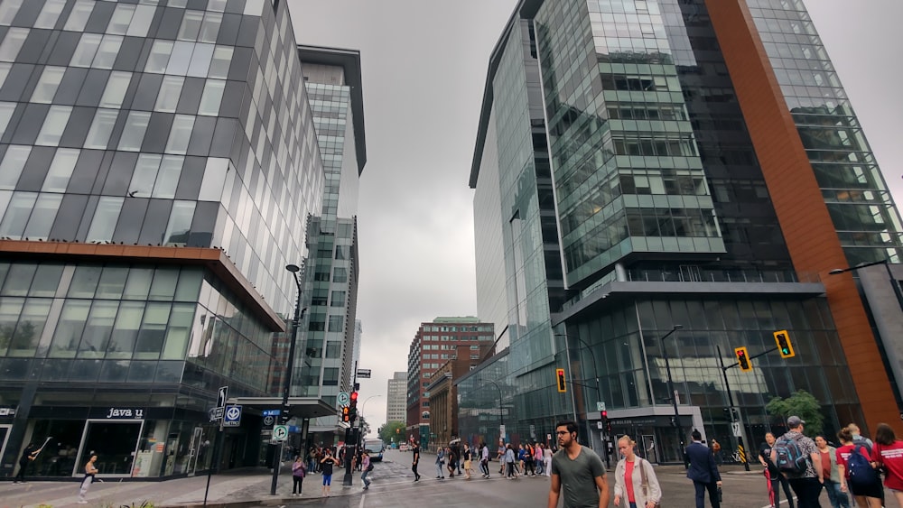 a group of people walking down a street next to tall buildings