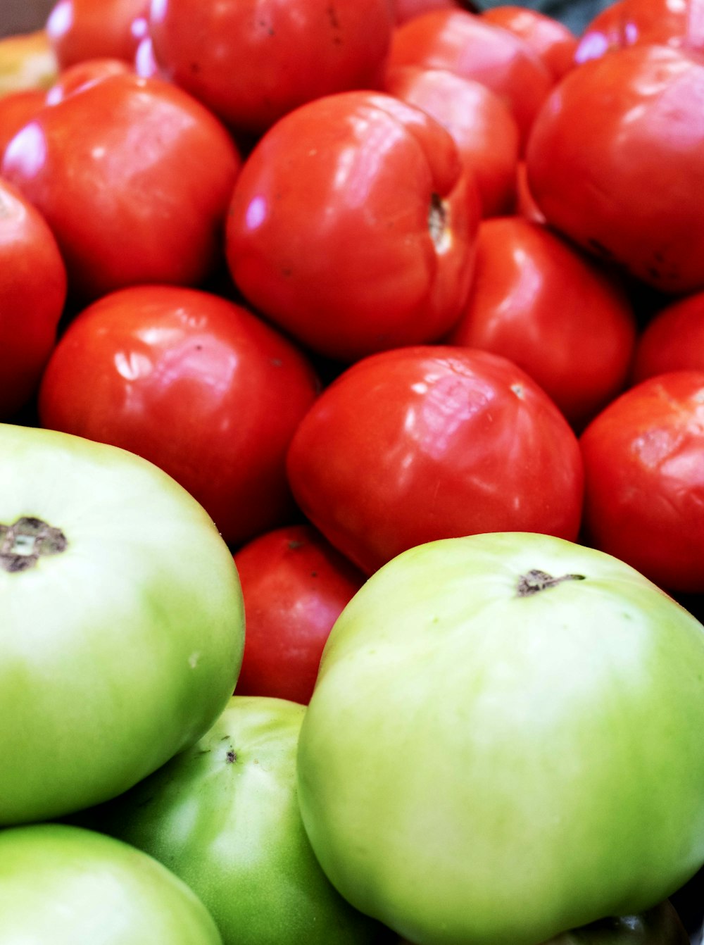 a pile of red and green apples sitting on top of each other