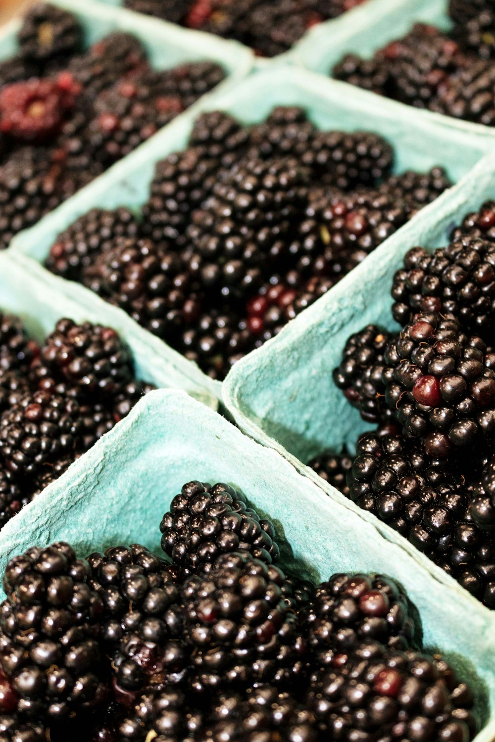 a bunch of blackberries are in baskets on a table