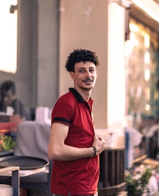 A model wearing a classic polo shirt outdoors in natural light.