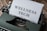 A typewriter with a sheet of paper in the carriage displaying the text 'WELLNESS TECH'. The typewriter is situated on a wooden surface, contributing to a vintage look.