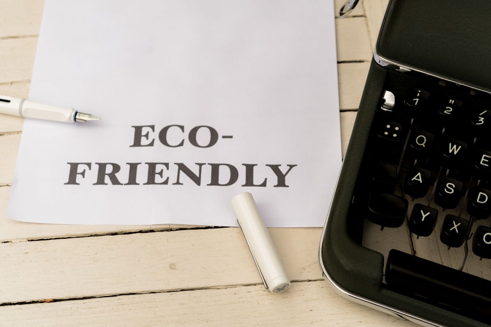a piece of paper that says eco - friendly next to a typewriter