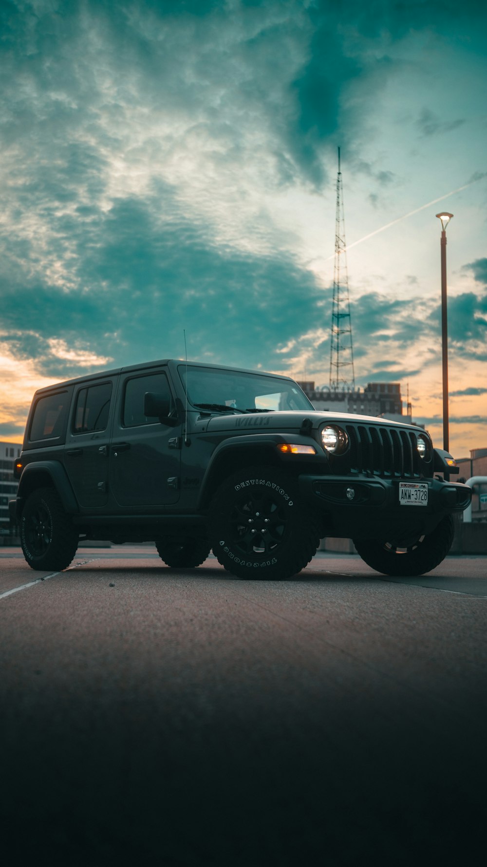 a black jeep is parked in a parking lot
