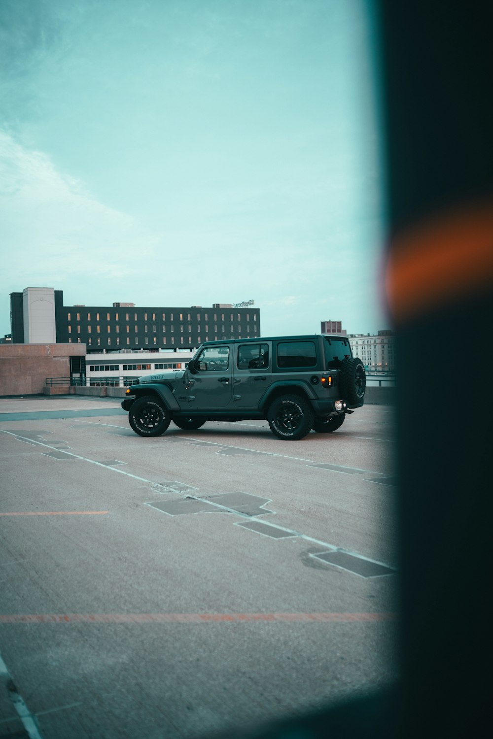 a black jeep is parked in a parking lot