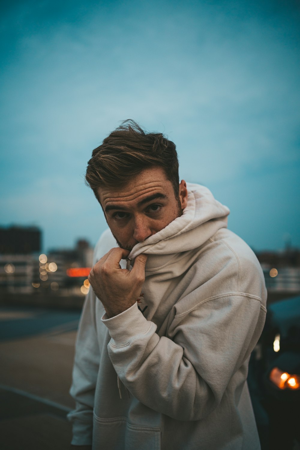 a man in a hoodie smoking a cigarette