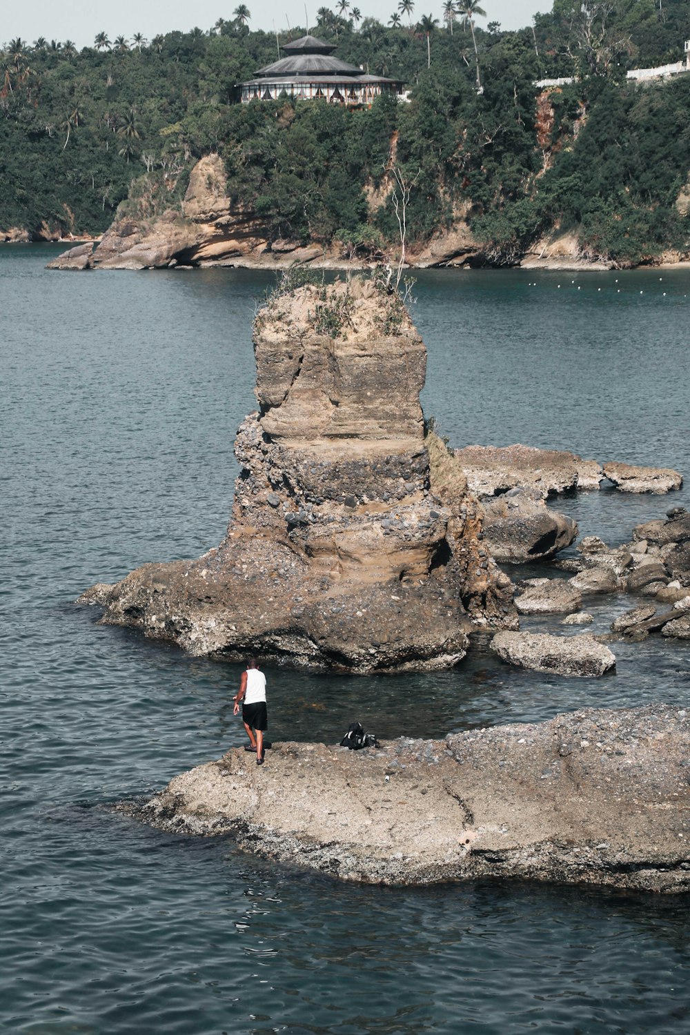 une personne debout sur un rocher au milieu d’un plan d’eau