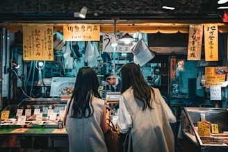 a couple of women standing next to each other in front of a store