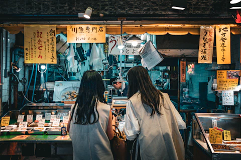 a couple of women standing next to each other in front of a store