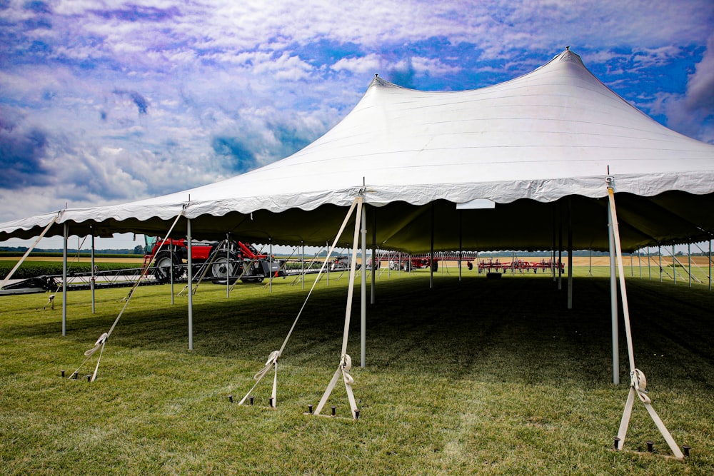 a large white tent sitting on top of a lush green field