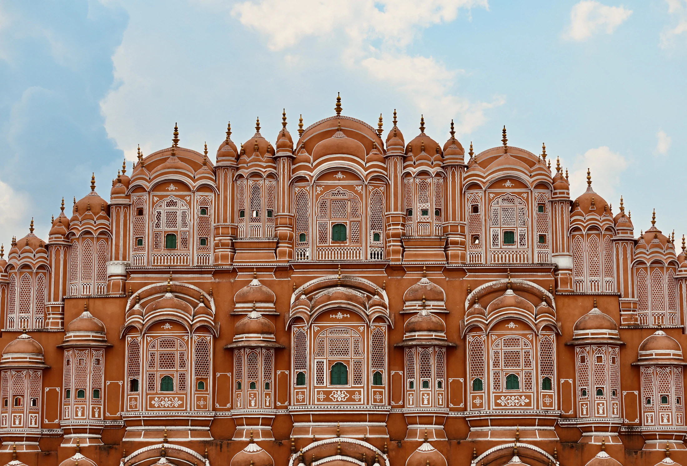 The full five-storey front of the Hawa Mahal under a blue sky