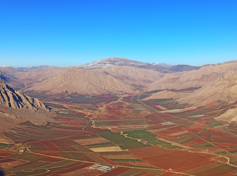 an aerial view of a valley with mountains in the background