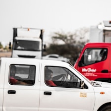A focused truck driver checking delivery details inside the cab.