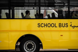a yellow school bus with arabic writing on the side