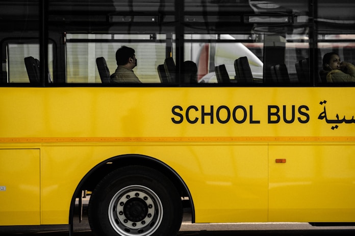 a yellow school bus with arabic writing on the side
