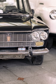A red Fiat hatchback displayed with polished floors reflecting its shine.