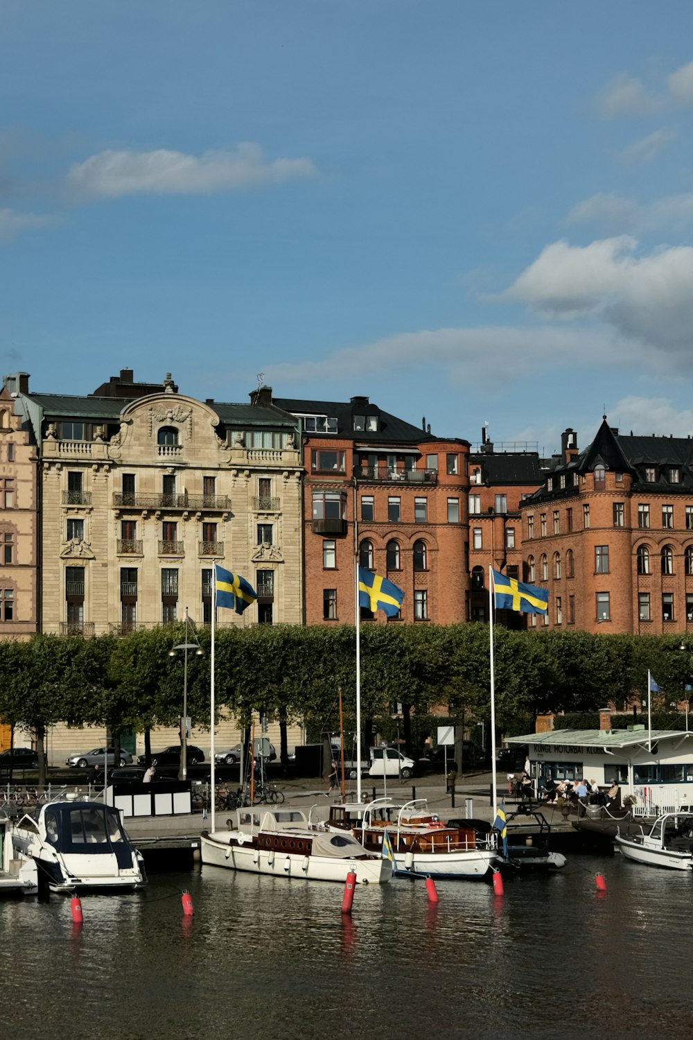 a group of boats sitting in a harbor next to tall buildings