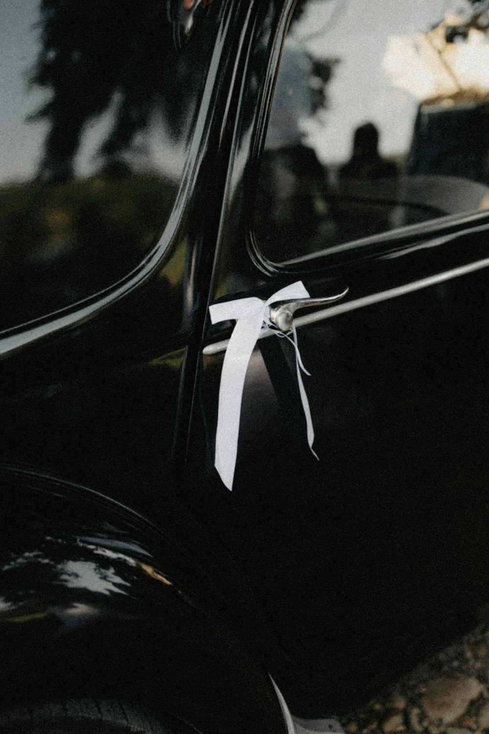 a black car with a white ribbon tied to it