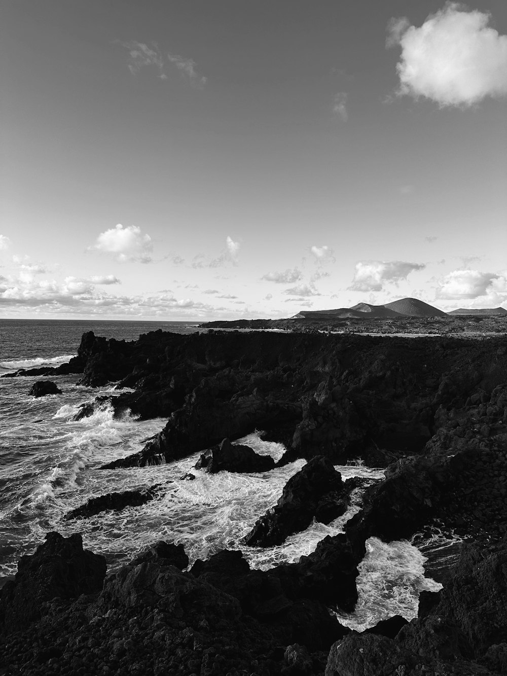 a black and white photo of a rocky coastline