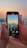 A smiling woman recording a video with her smartphone outdoors during golden hour.