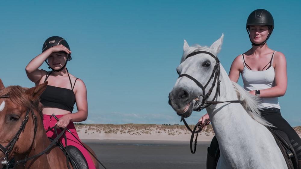 a couple of women riding on the backs of horses