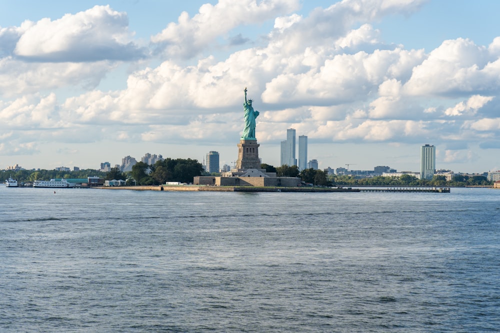 a body of water with a statue of liberty in the background
